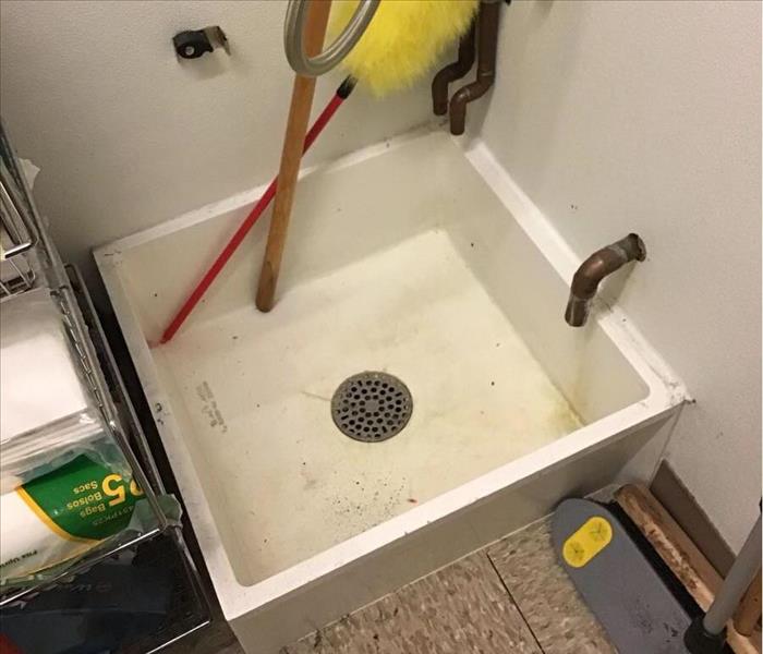 A clogged mop sink after cleaning